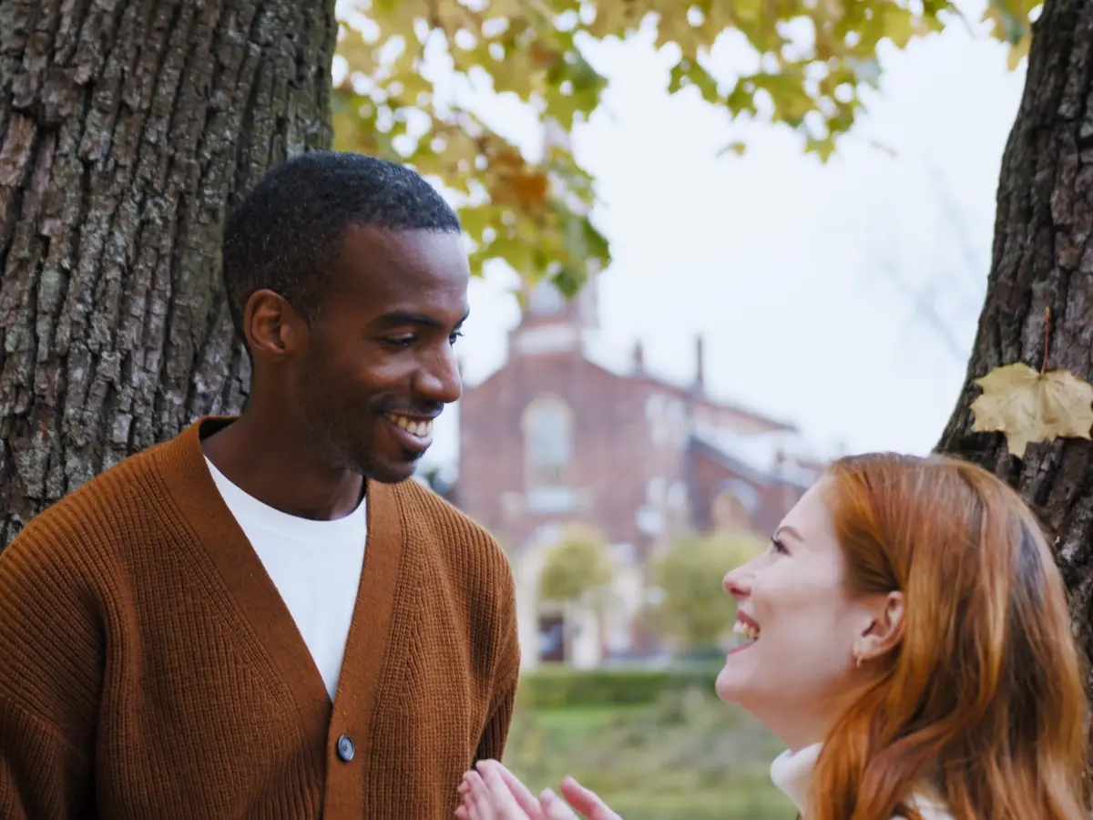 A couple laughing together under an autumn tree