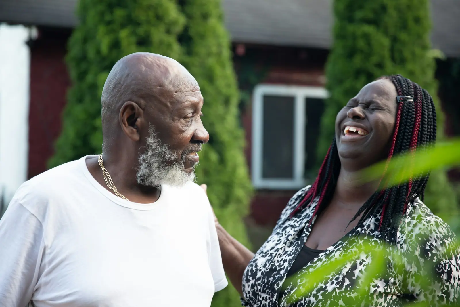 An older couple laughing together in a garden